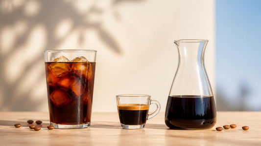 Iced cold brew, a small espresso and a carafe of cold brew concentrate side by side
