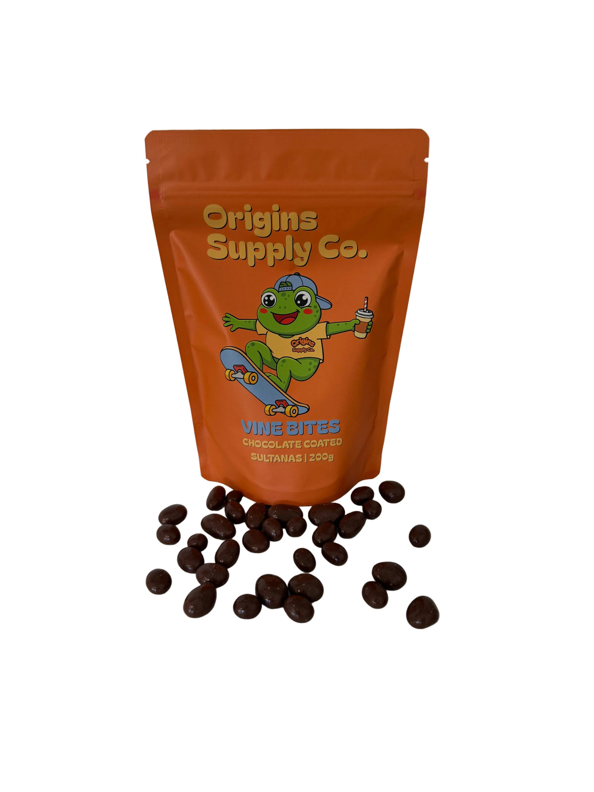 An orange stand-up pouch of Origins Supply Co. Vine Bites Chocolate Covered sultanas stands on a white marble countertop with several chocolate-coated banana pieces scattered in front.